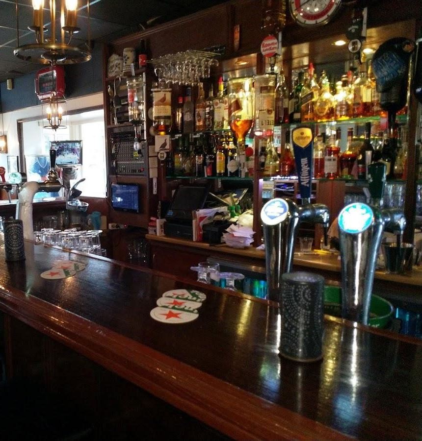 De bar met tapkranen en een wand vol flessen