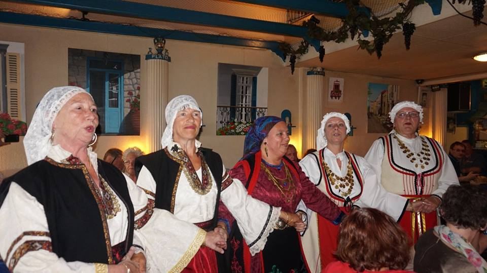 Griekse dansgroep in klederdracht zingt in het restaurant